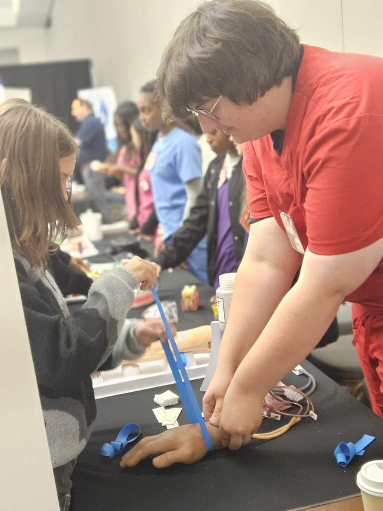 Med Lab students at world of works showing their program to 8th graders.
