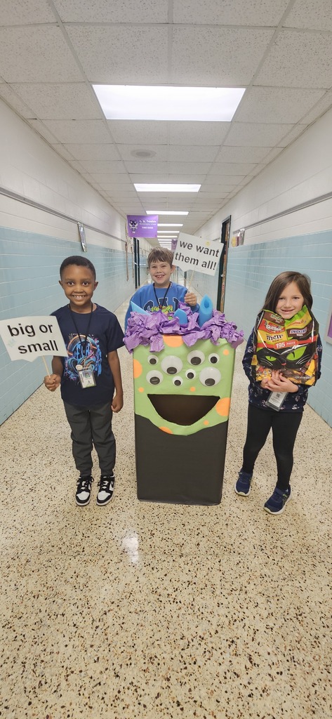 Students posing with Victor the candy  monster, sign says "Big or small, we want them all!"
