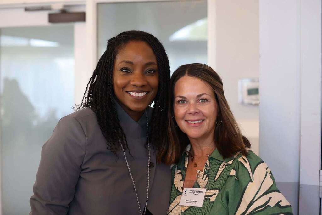 Principal Kinyatta Garrett and a community member smiling together.
