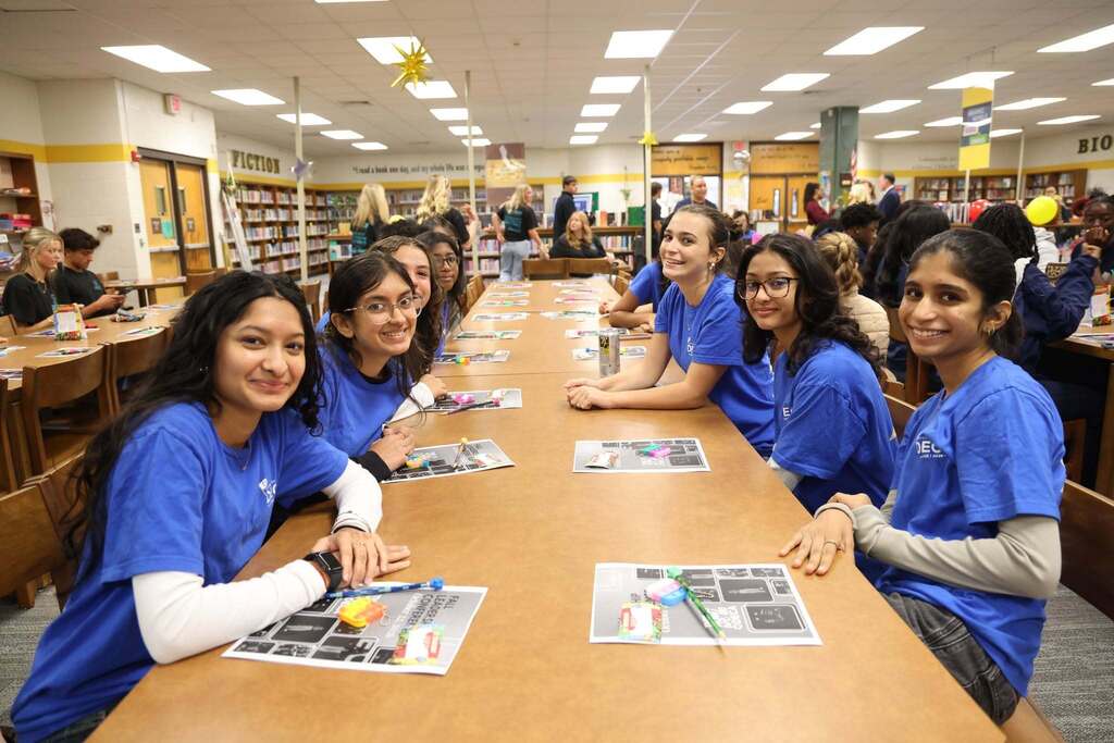 DECA Students smile from table