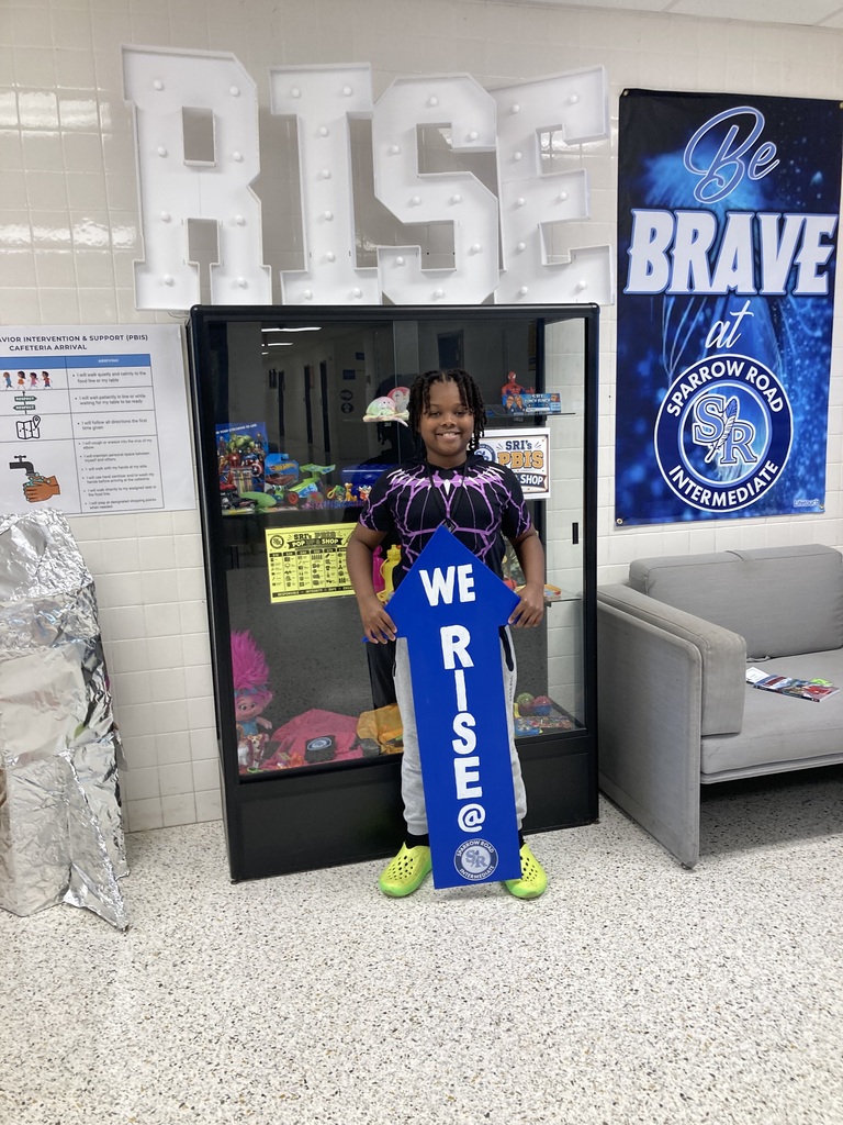 Student holding the RISE arrow proudly.