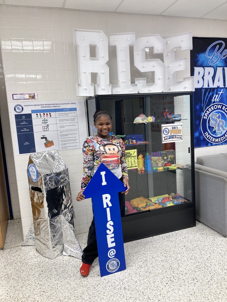 Student holding the RISE arrow proudly.