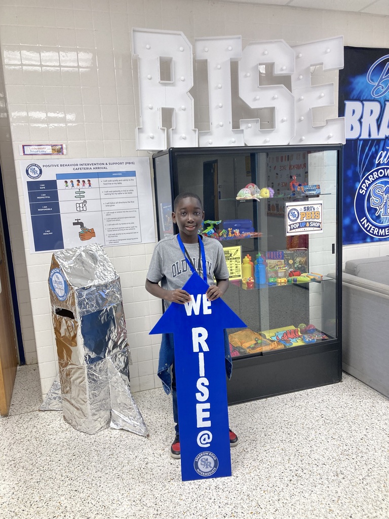 Student holding the RISE arrow proudly.