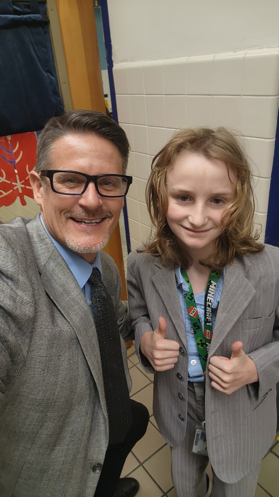 Selfie of Mr. Triolet and a student giving the thumbs up in his suit.