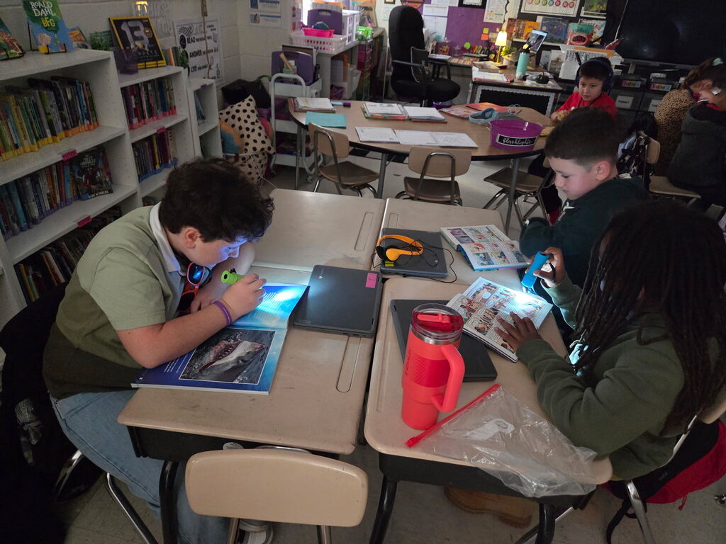 students reading with flashlights in the classroom