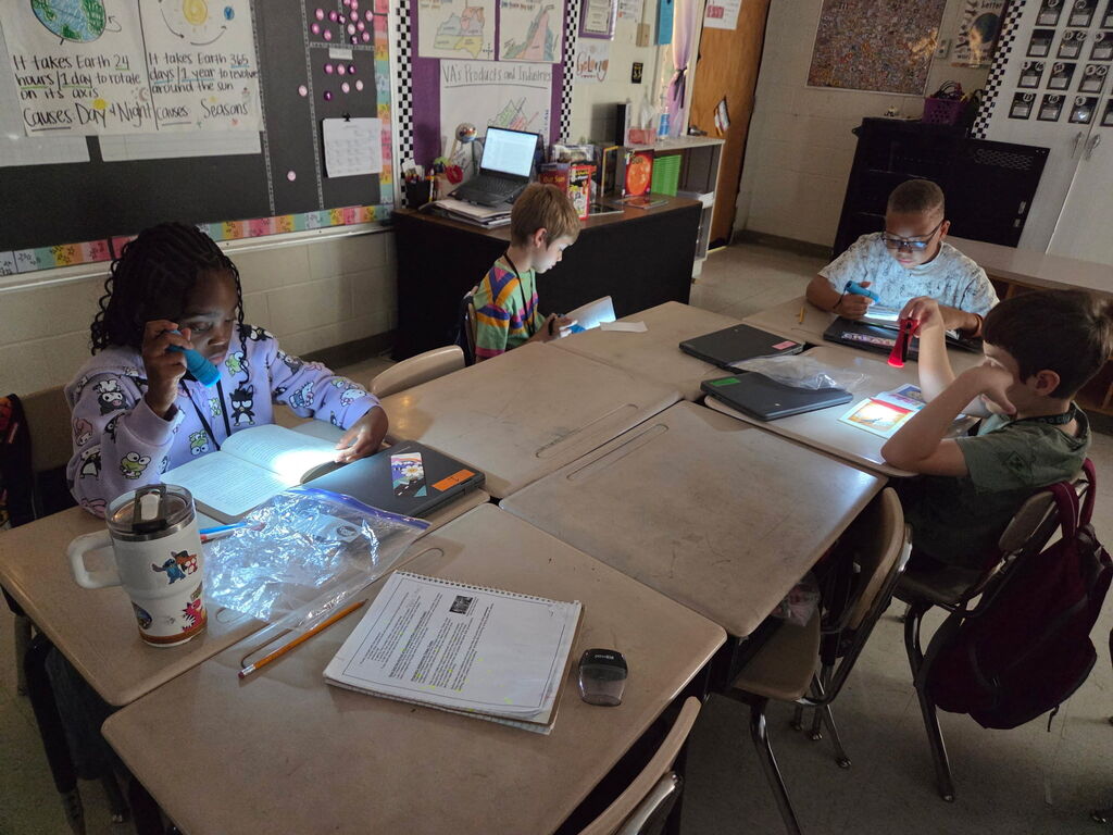 students reading with flashlights in the classroom