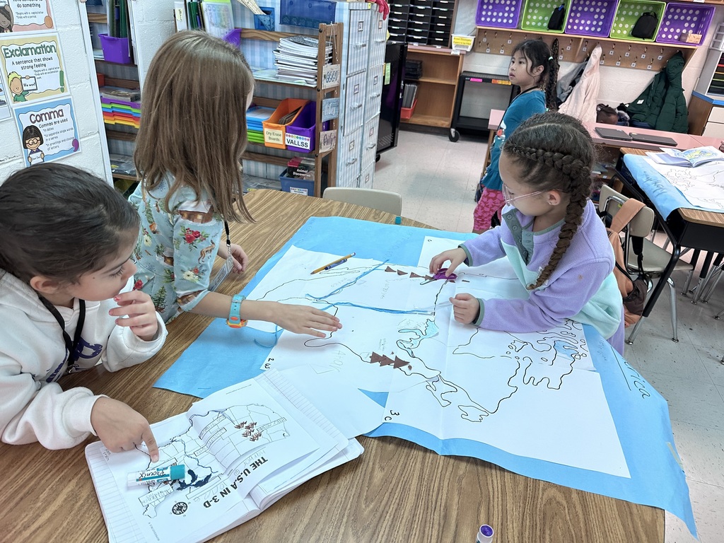 2nd graders working together to construct a map of north america