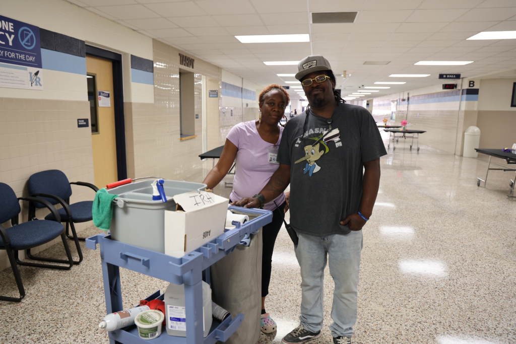 two custodians with cart smiling