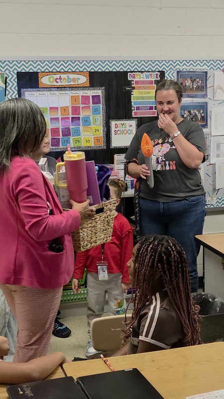 principal presenting gift basket to teacher of the year