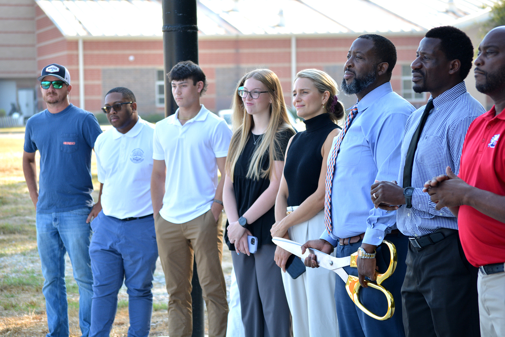 Staff and community members gather to celebrate the opening of the new baseball/softball fields.