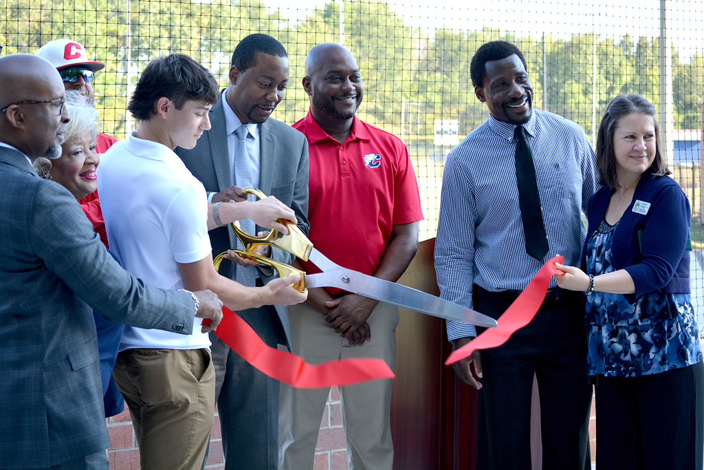 Staff and community members gather to celebrate the opening of the new baseball/softball fields.