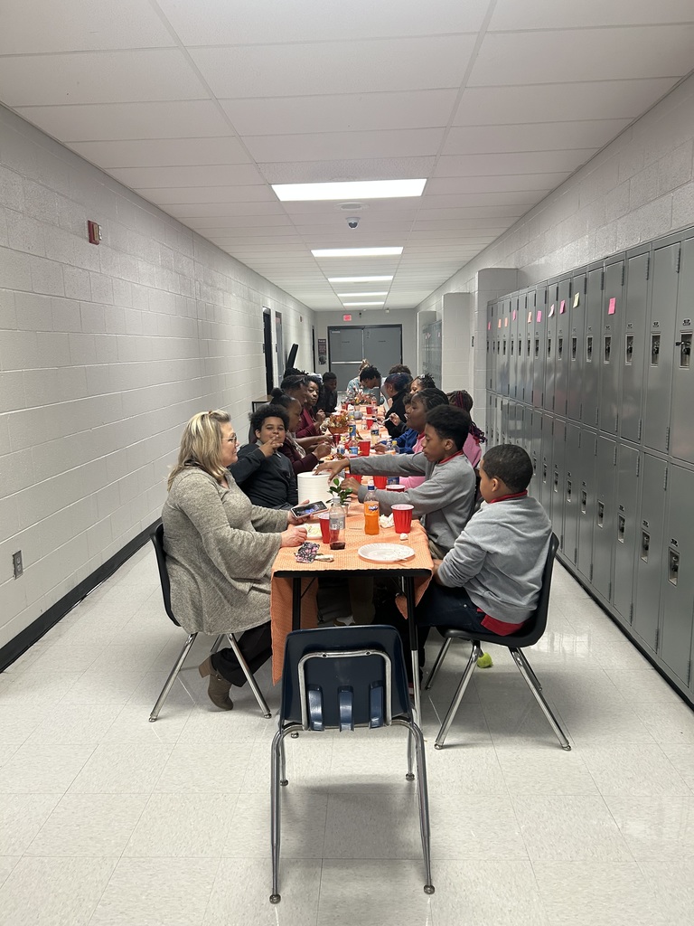 Students and staff eating Thanksgiving meal together.