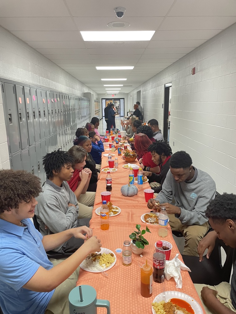 Students and staff eating Thanksgiving meal together.
