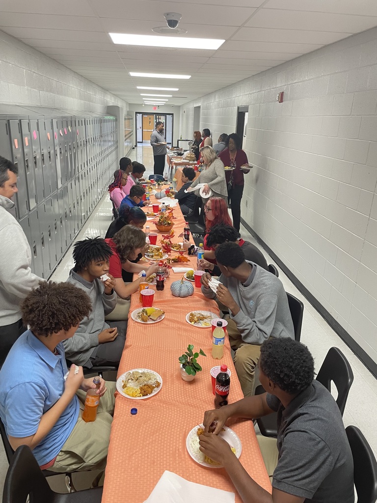 Students and staff eating Thanksgiving meal together.