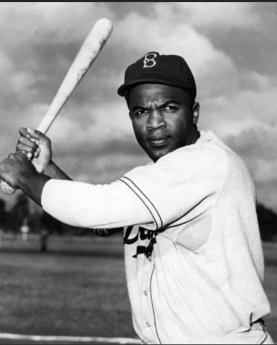 Jackie Robinson in Dodgers uniform with baseball bat. 