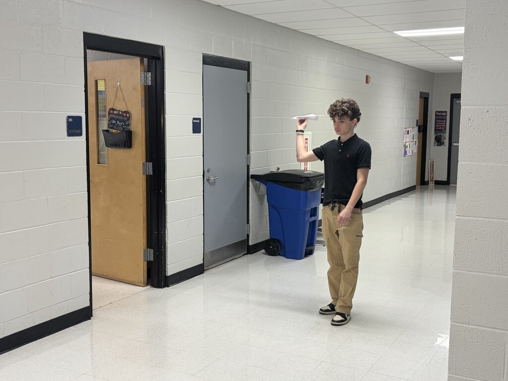 A student preparing to launch his airplane. 