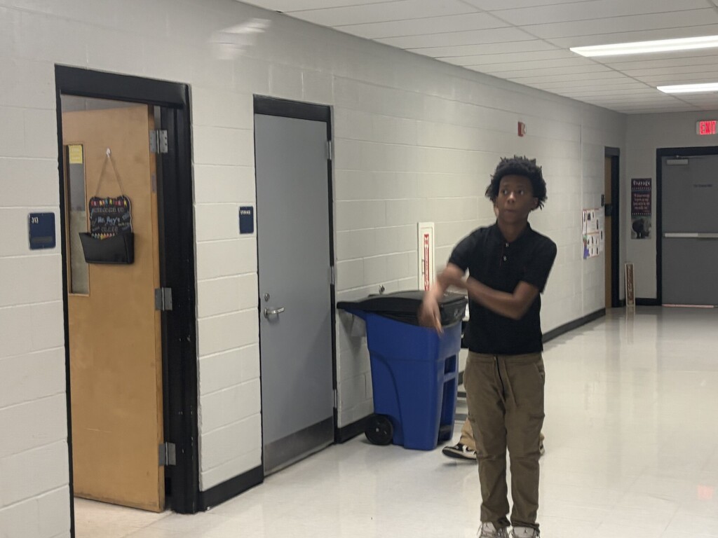 A student watching his airplane fly in a blur down the hall. 