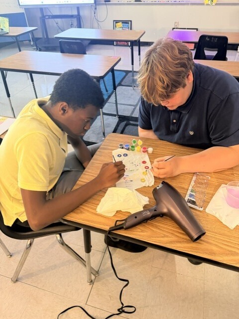 Students painting parts of their game. 