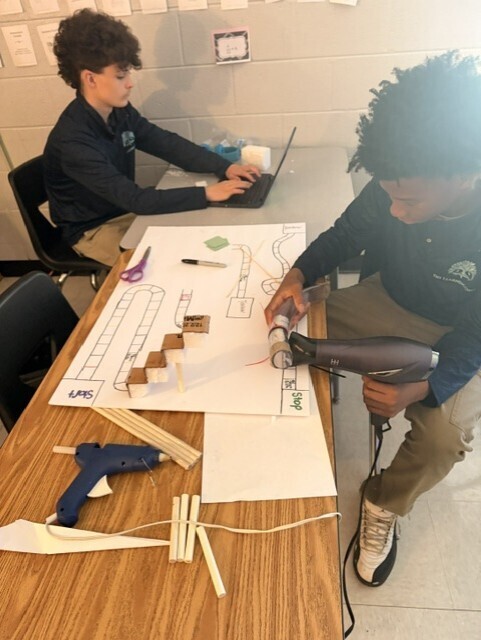 Students working on game elements and putting the board together. 