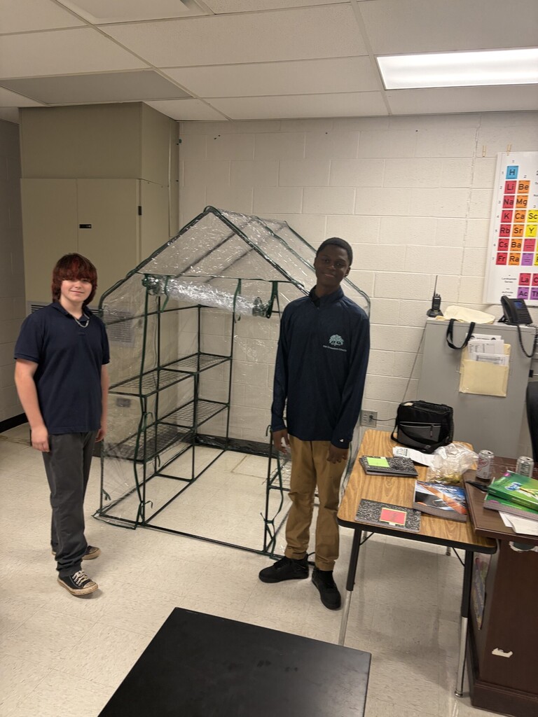 Students showing off the greenhouse they built for starting seeds in science.
