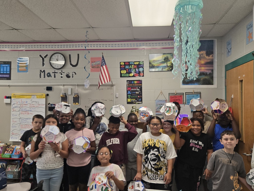 Students show off their dodecahedrons they made.