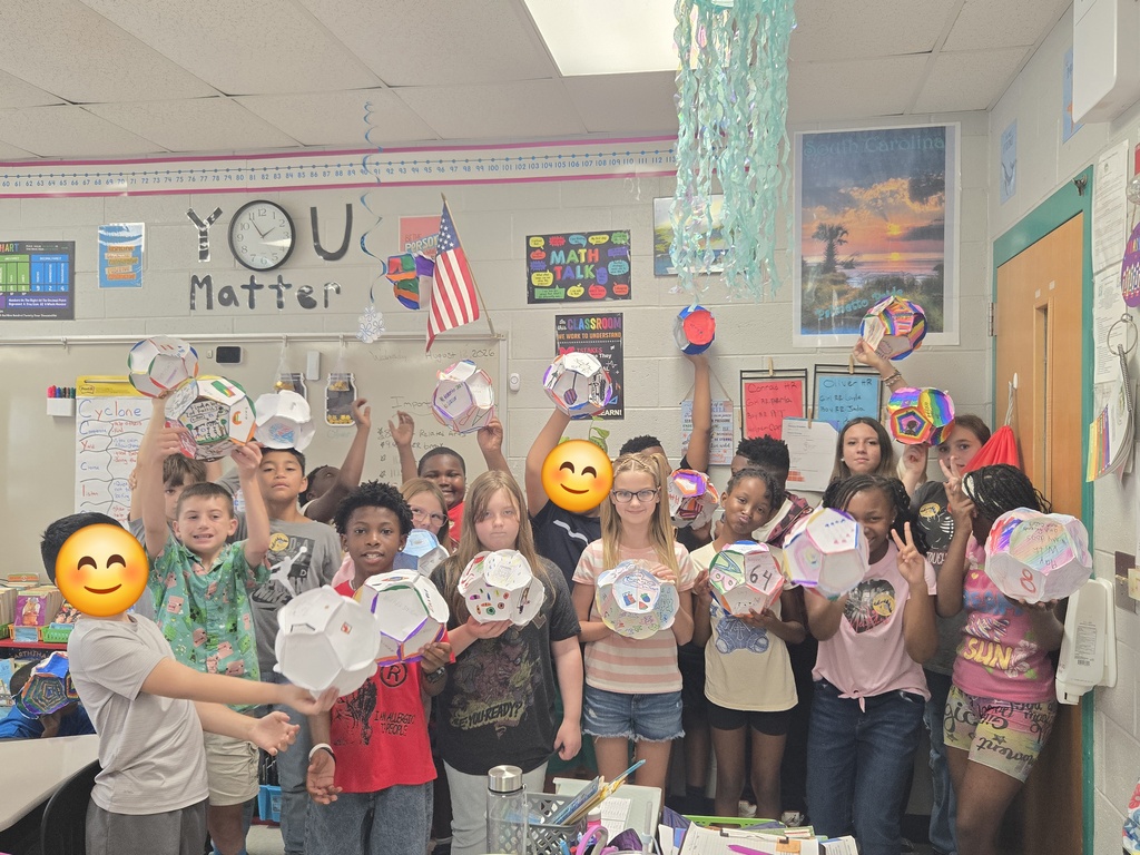 Students show off their dodecahedrons they made.
