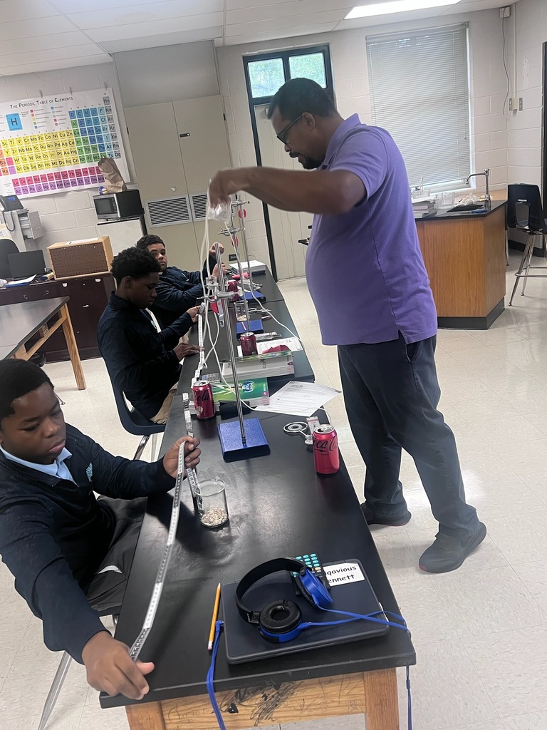 Mr. Ray demonstrating how to use the weights and measures. 