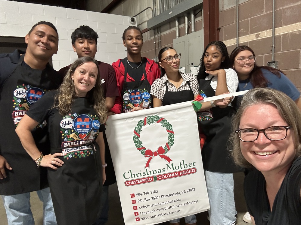 Spanish Immersion volunteers holding Christmas Mother banner