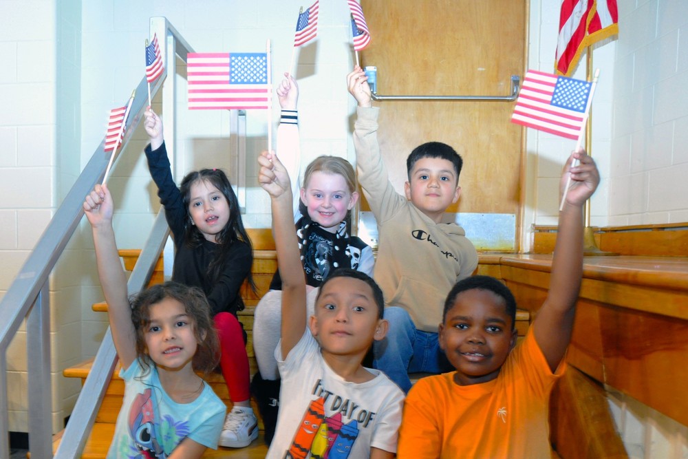 Six students holding up American flags