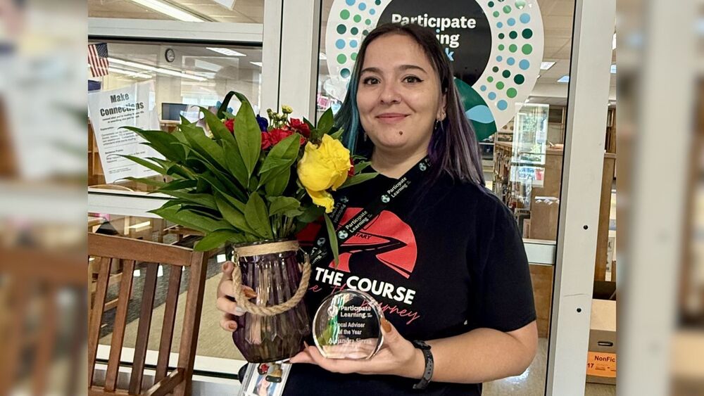 Alejandra Sierra holding an award and flowers