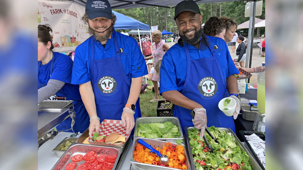 Two men smiling and serving food