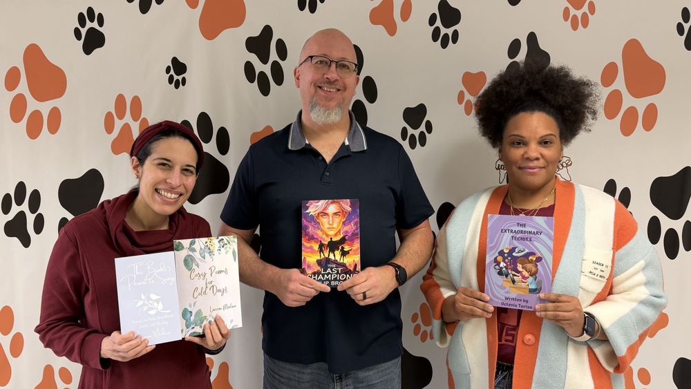 Three authors holding their books
