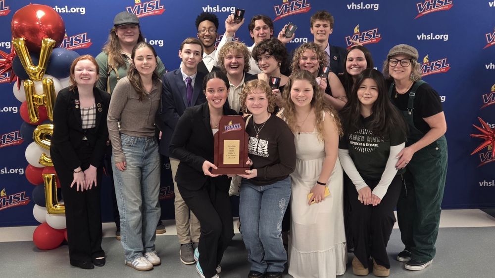 Group of students holding a plaque and smiling