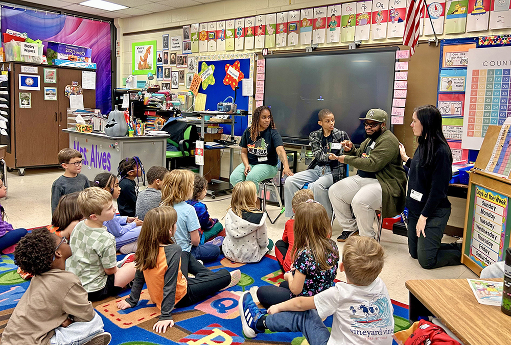 Visitors teaching the students to sign