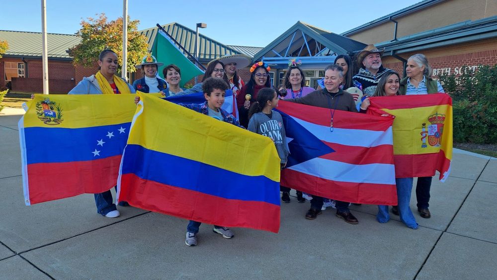 Students and teachers holding flags of hispanic nations