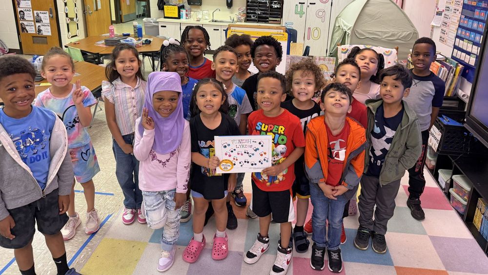 A group of students posing and smiling with their book