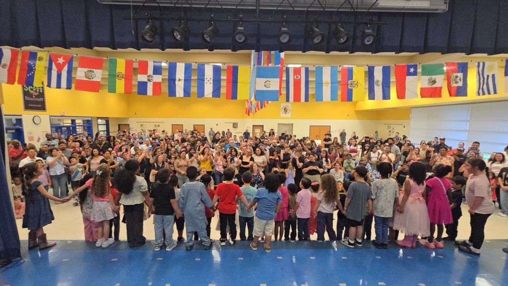 Students gathered with flags of nations above them