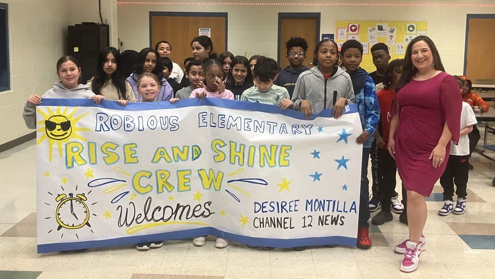 Students holding up a banner welcoming Desiree Montilla