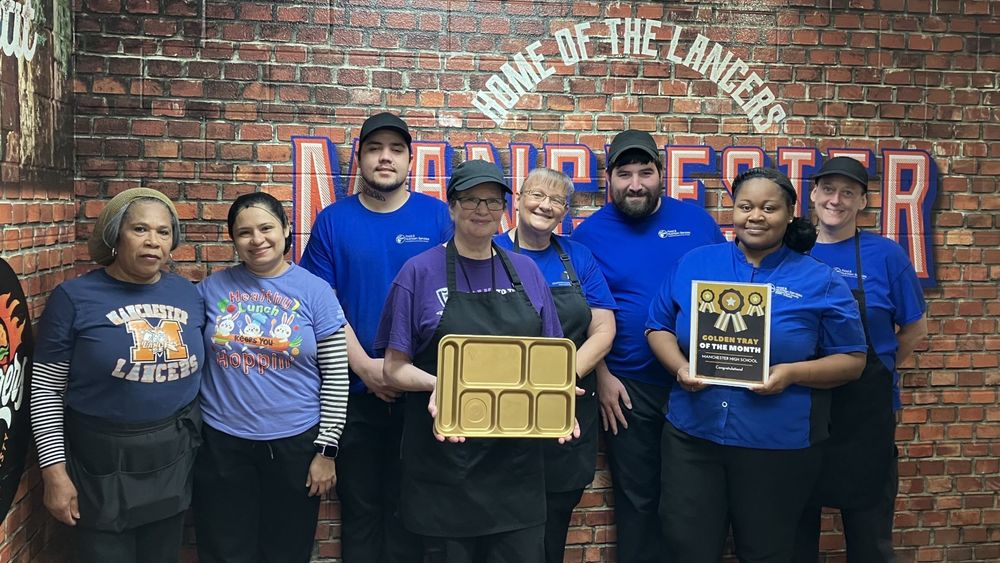 Food service workers holding the golden tray