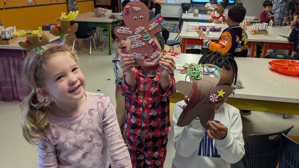 Kids holding up handmade gingerbread people