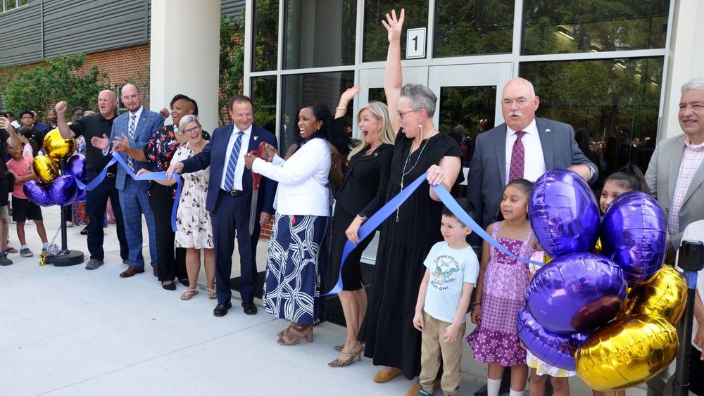 Local leaders and children celebrating a ribbon cutting
