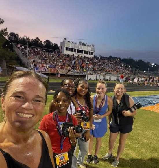 Mass Communication students with internship leader at Manchester football game