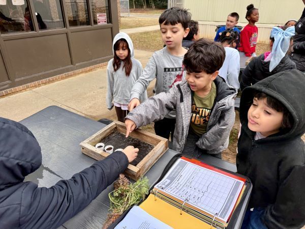 Students looking at a table-top garden plot