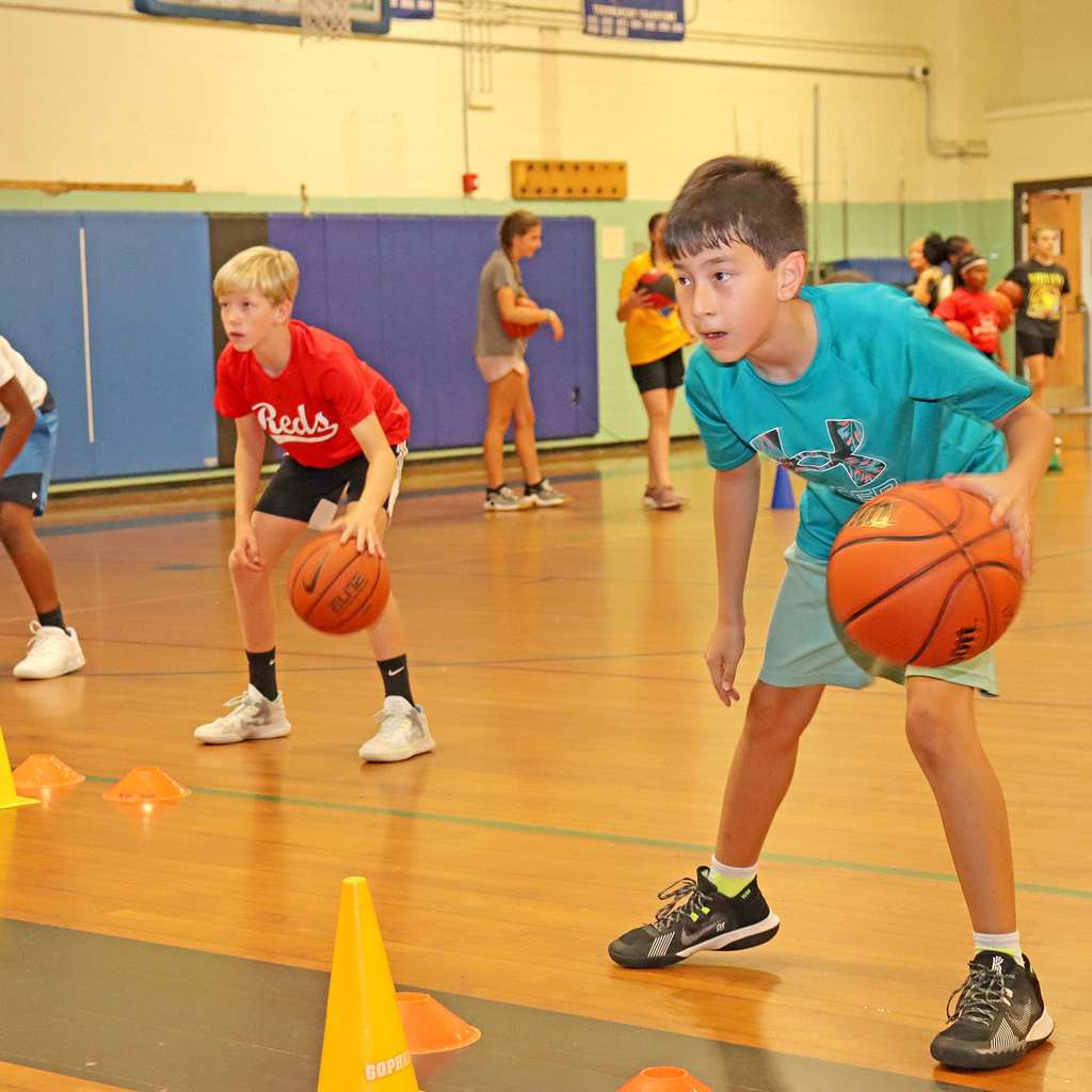 A group of boys dribbling a basketball ball