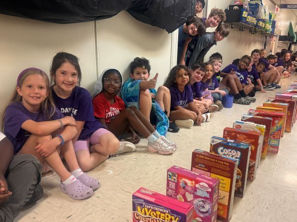 Students seated next to cereal boxes lined up
