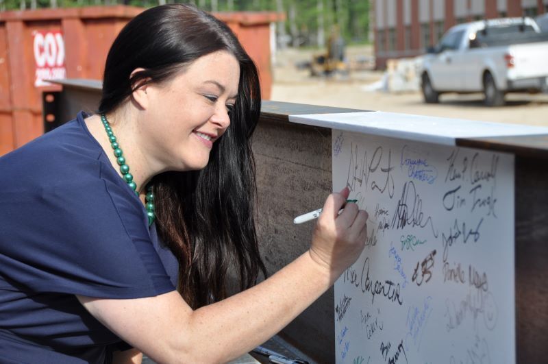 Dr. Baber signing the beam