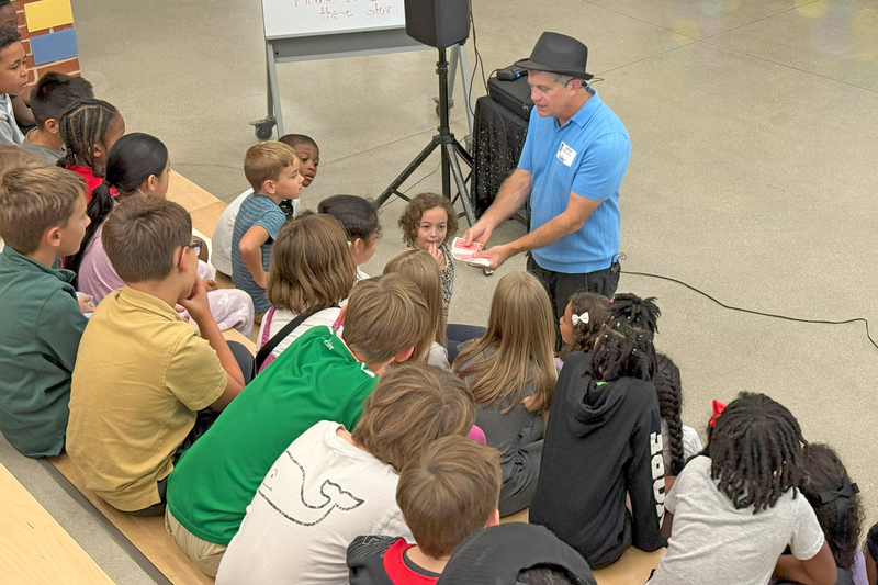 Performer showing kids a handful of playing cards