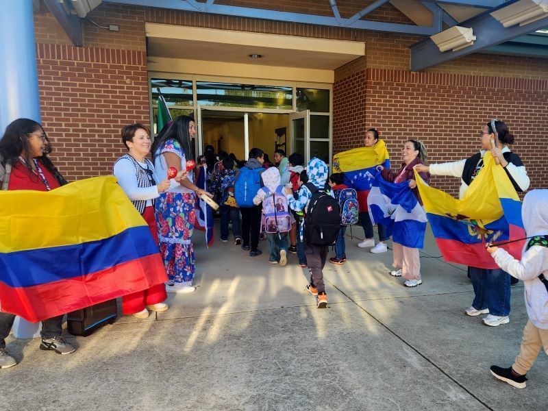 Teachers welcoming students with flags