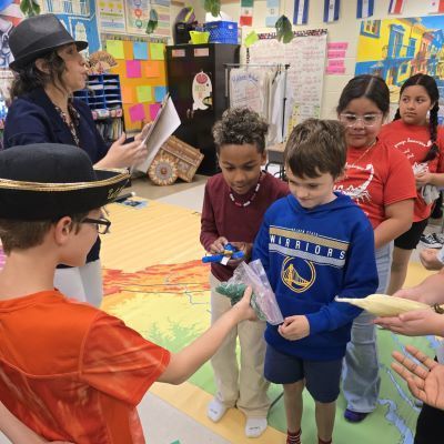 Students in a line facing a student in a hat