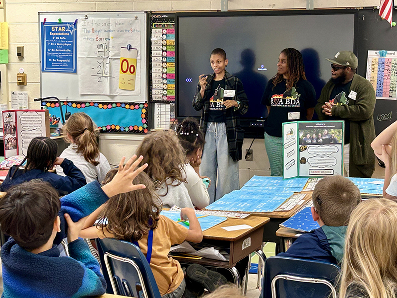Visitors teaching the students to sign